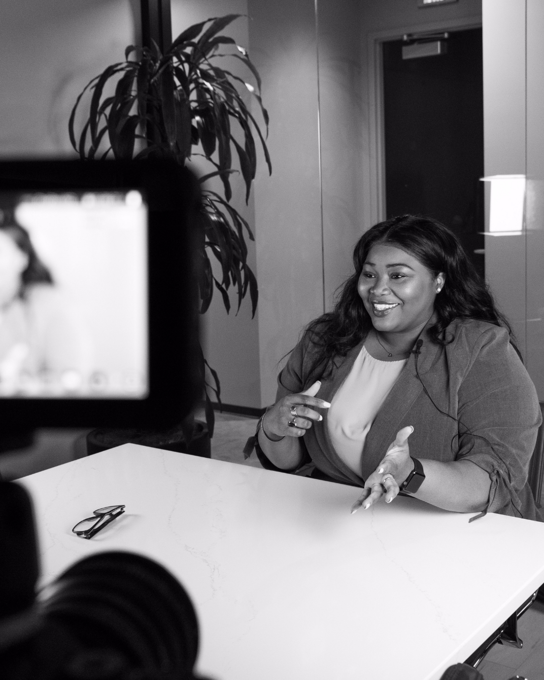 Black and white photo of Georgina Dukes-Harris being interviewed on camera.